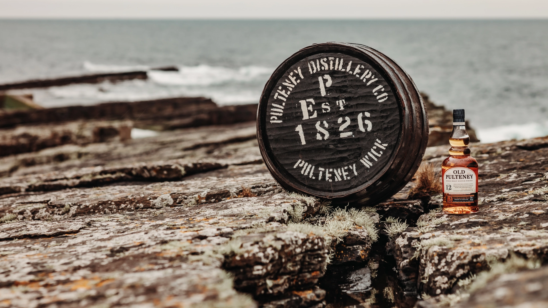 Old Pulteney 12yo bottle shot with barrel at sea landscape